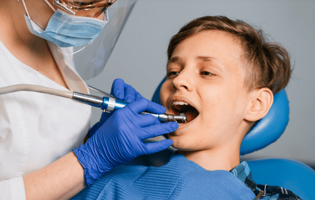 Child receiving a preventive dental exam from a dentist during a routine checkup.